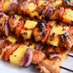 bbq pineapple chicken kabobs on grill with pineapple and peppers
