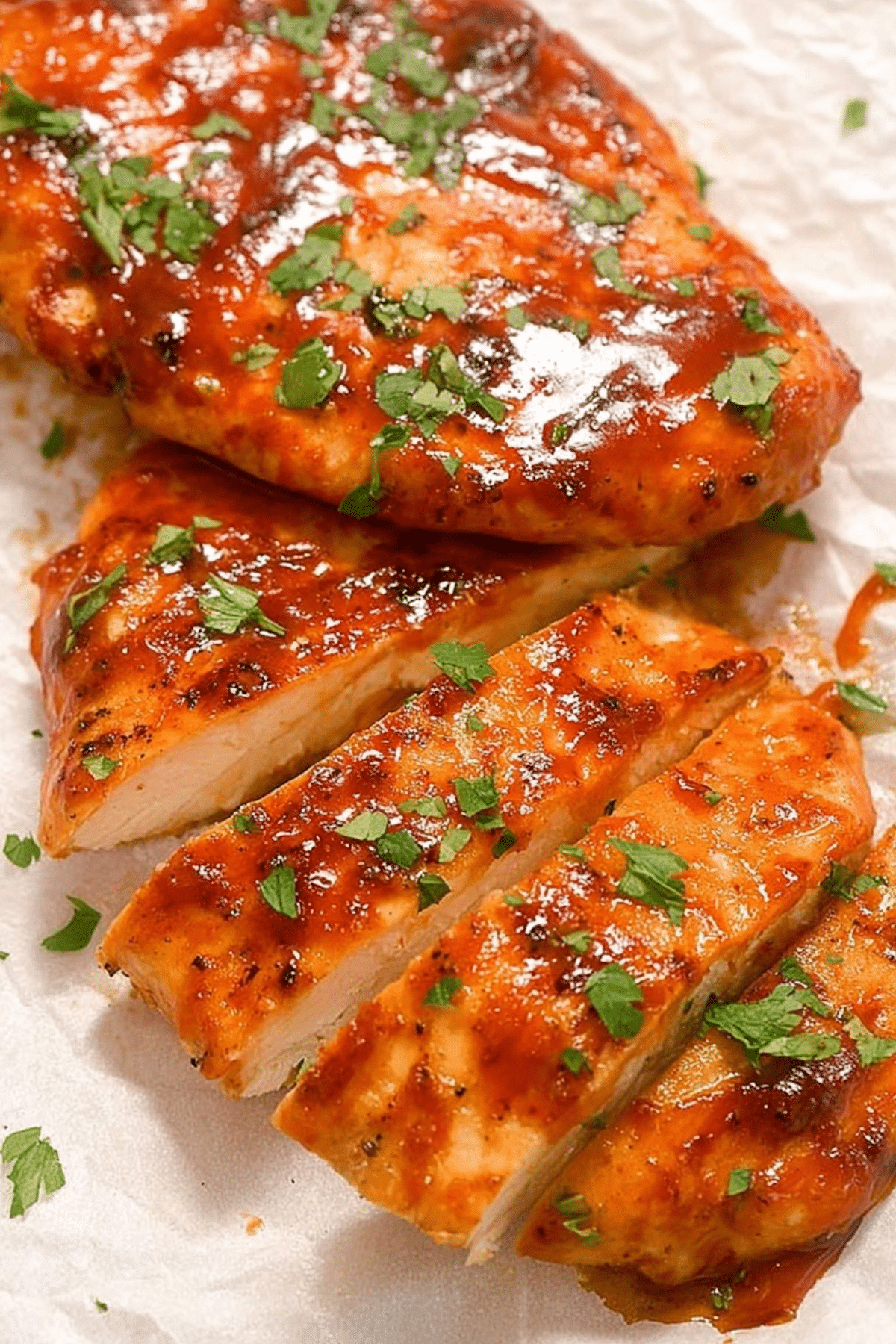 Air Fryer BBQ Chicken Breast served with BBQ sauce and fresh herbs