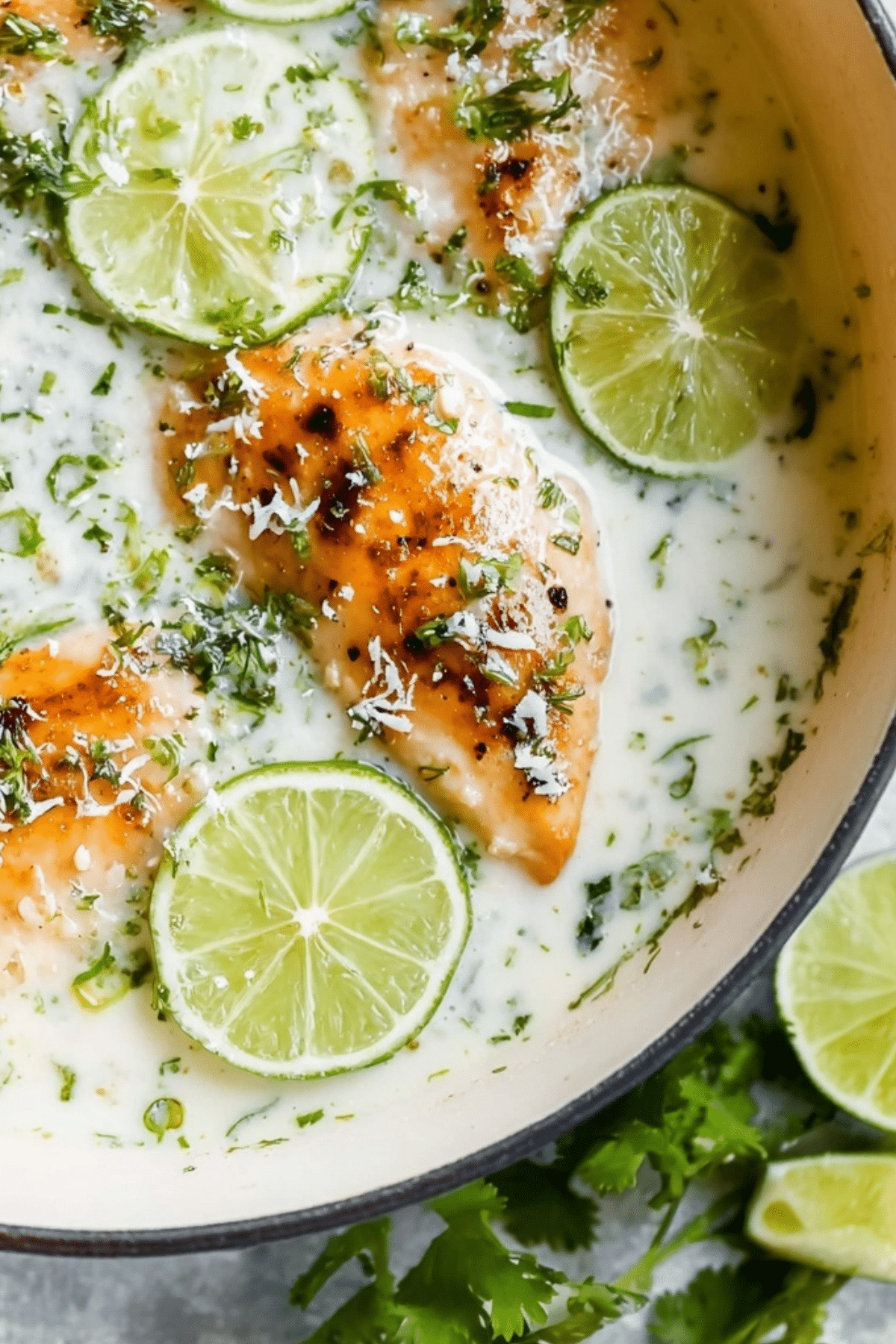 Creamy Coconut Lime Chicken served in skillet with lime and cilantro