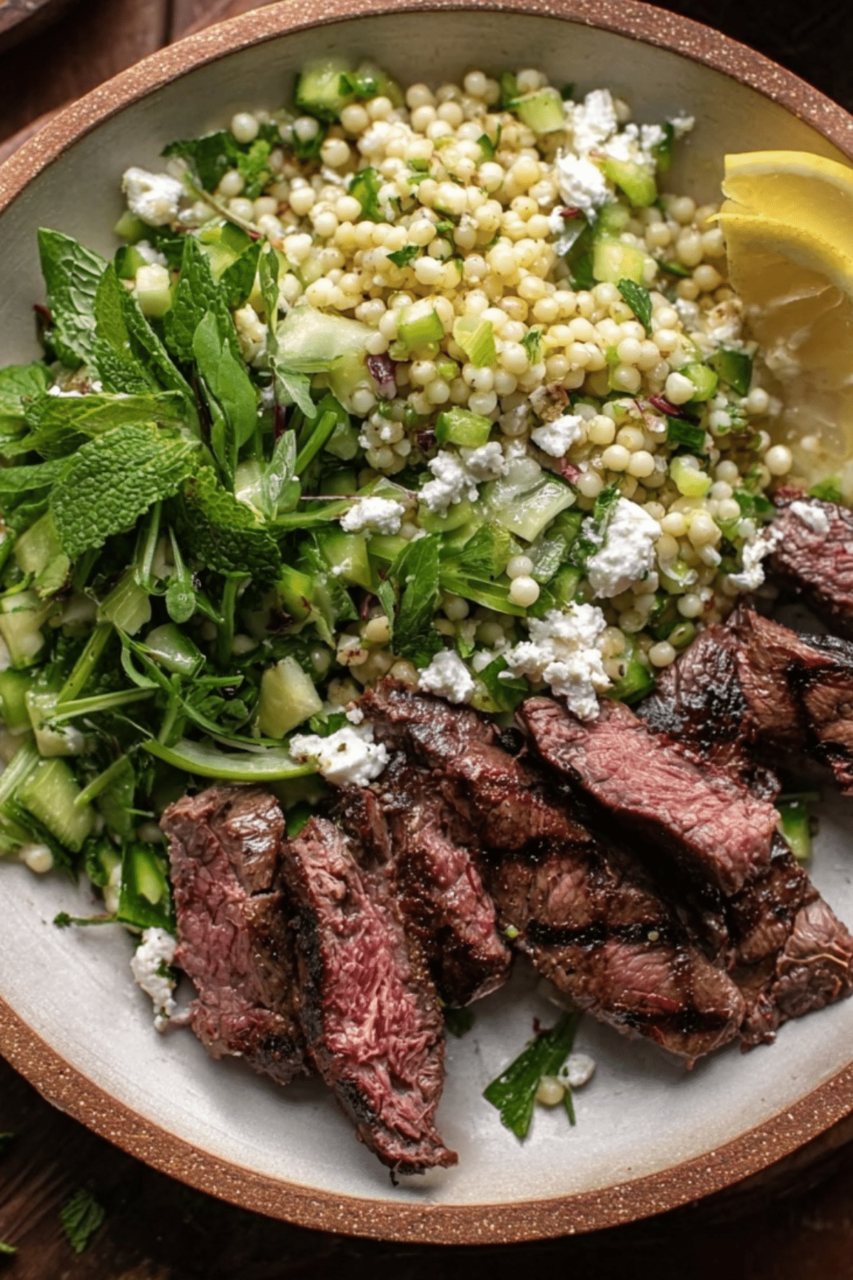 Grilled Skirt Steak with Lemon Herb Couscous Salad served on a plate