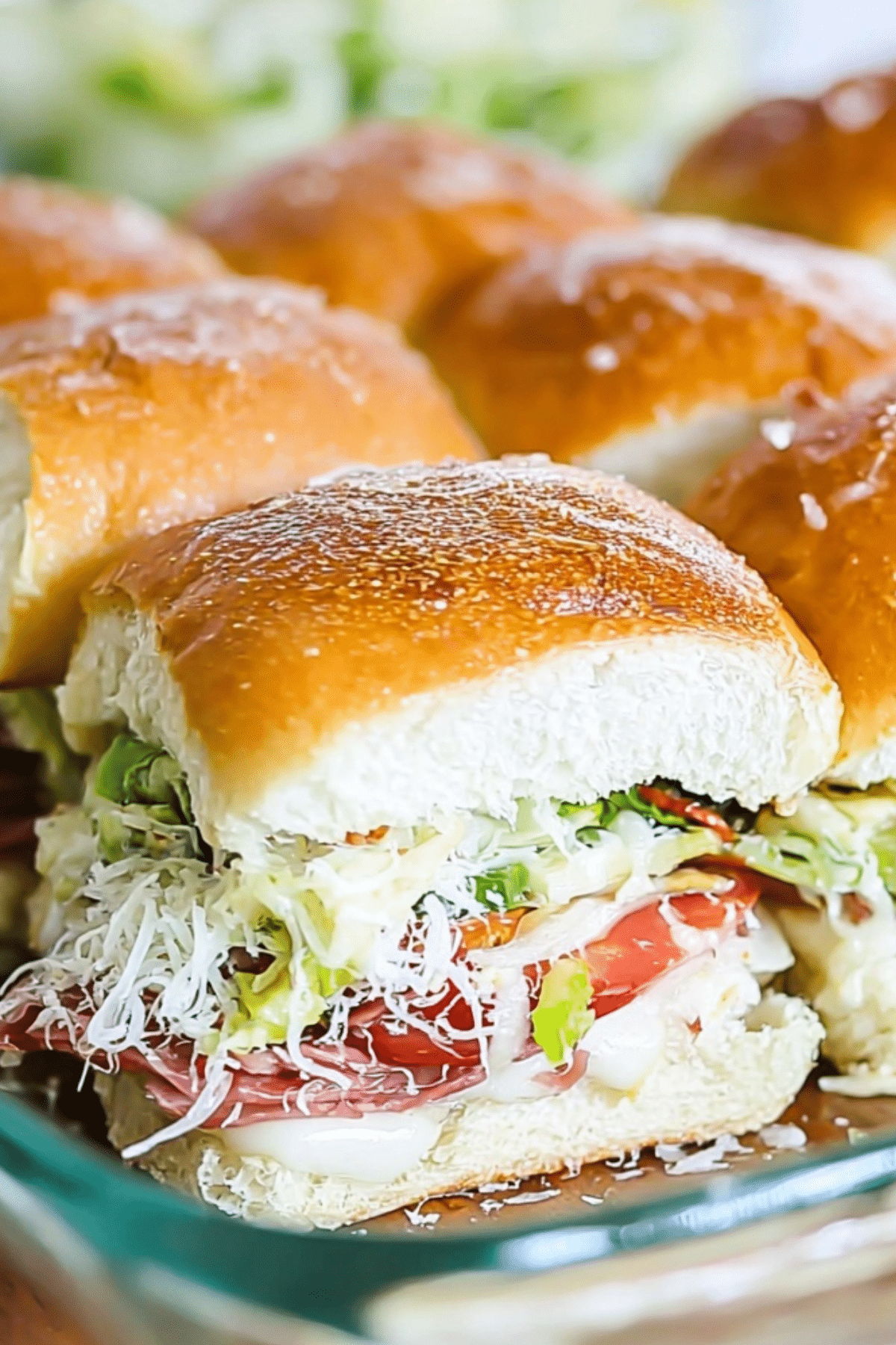 Italian Grinder Sliders on a plate with melted cheese and savory meats
