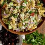 Mediterranean Pasta Salad served in a bowl with fresh vegetables and crumbled goat cheese