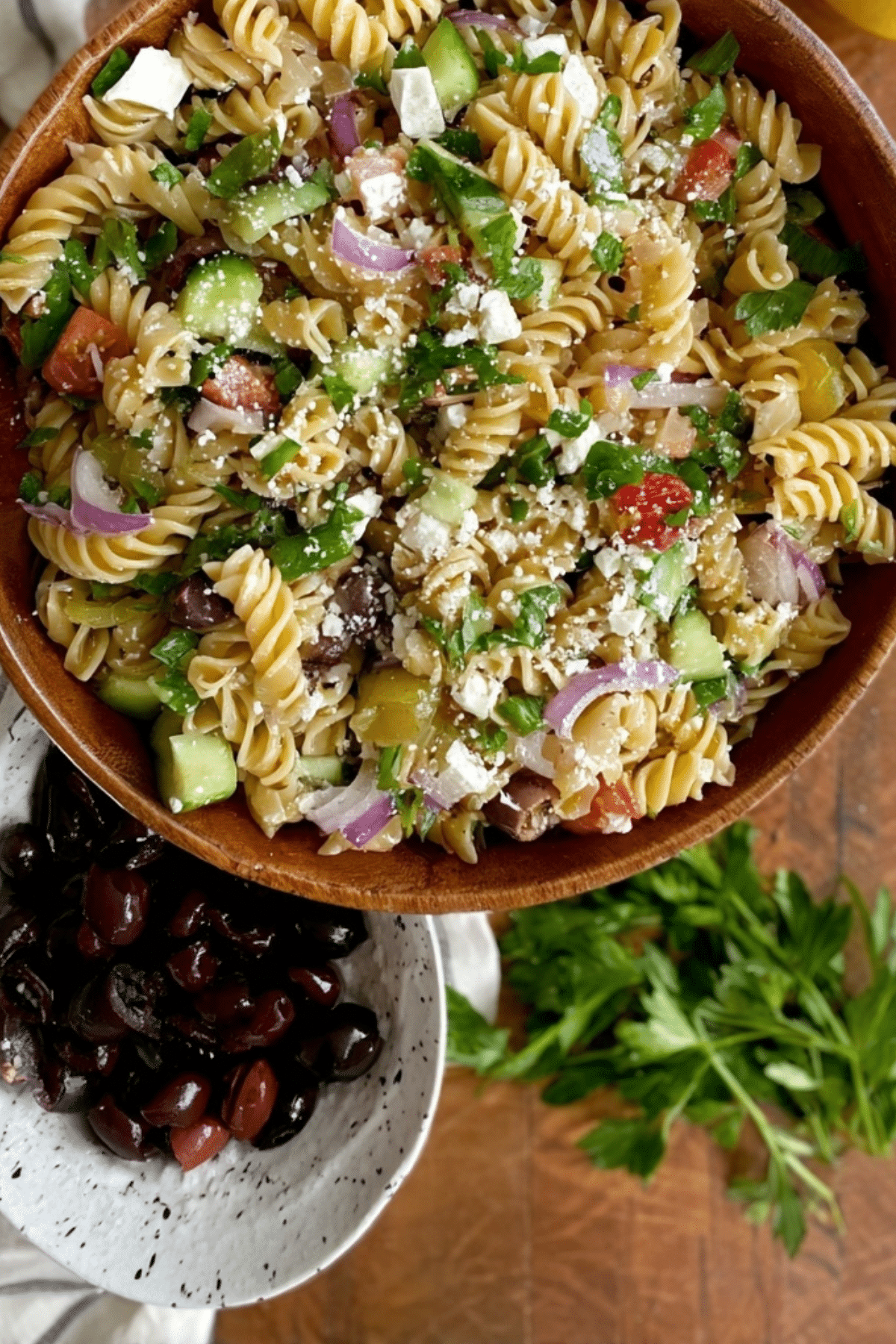 Mediterranean Pasta Salad served in a bowl with fresh vegetables and crumbled goat cheese