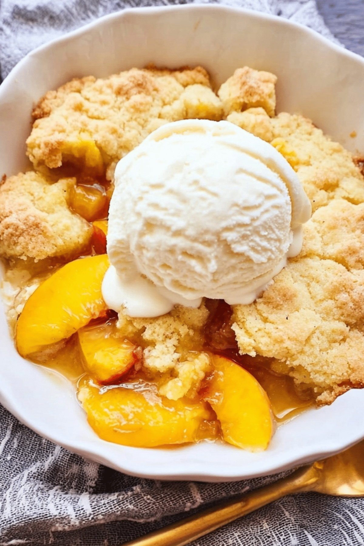 Nectarine cobbler with golden buttery topping and vanilla ice cream