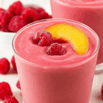 Raspberry Peach Smoothie served in a glass with fruit