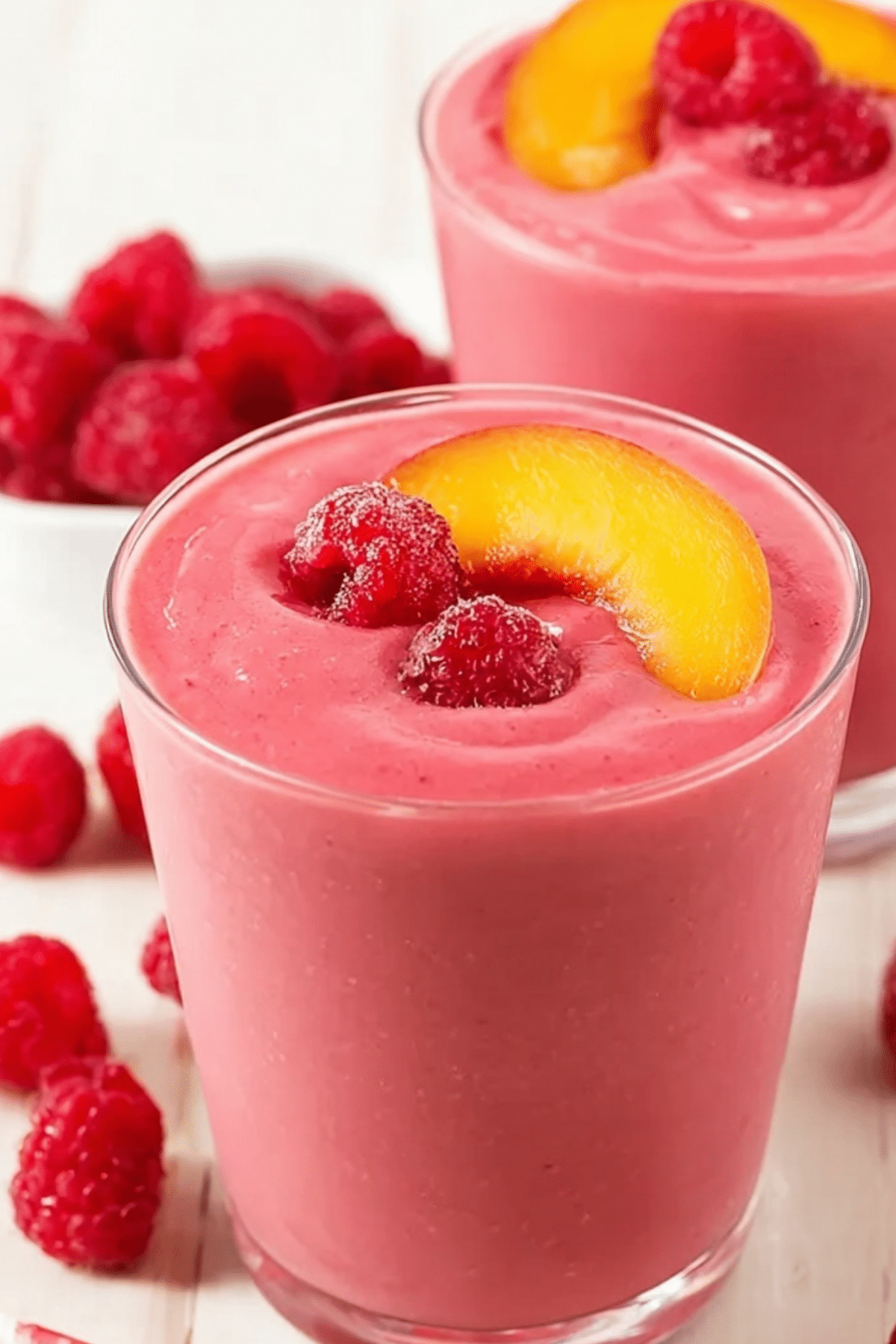 Raspberry Peach Smoothie served in a glass with fruit