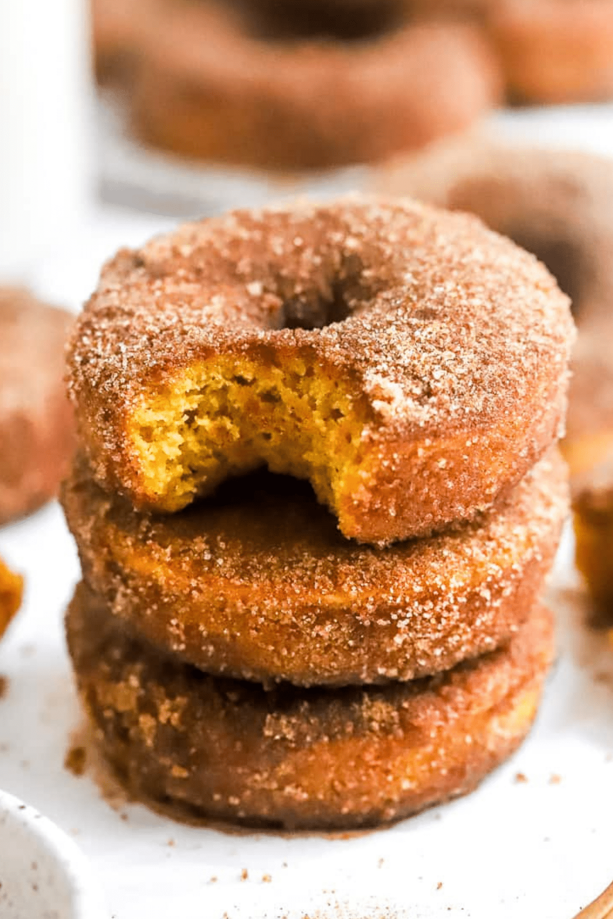 Baked pumpkin donuts dusted with cinnamon sugar on a plate
