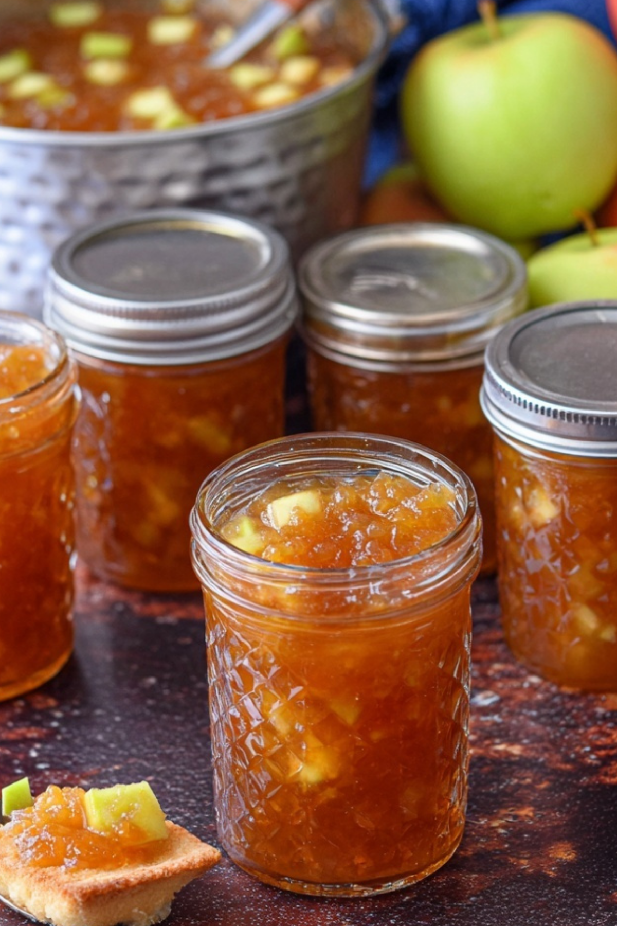 Apple Pie Jam in a jar with cinnamon sticks and apples, perfect for canning