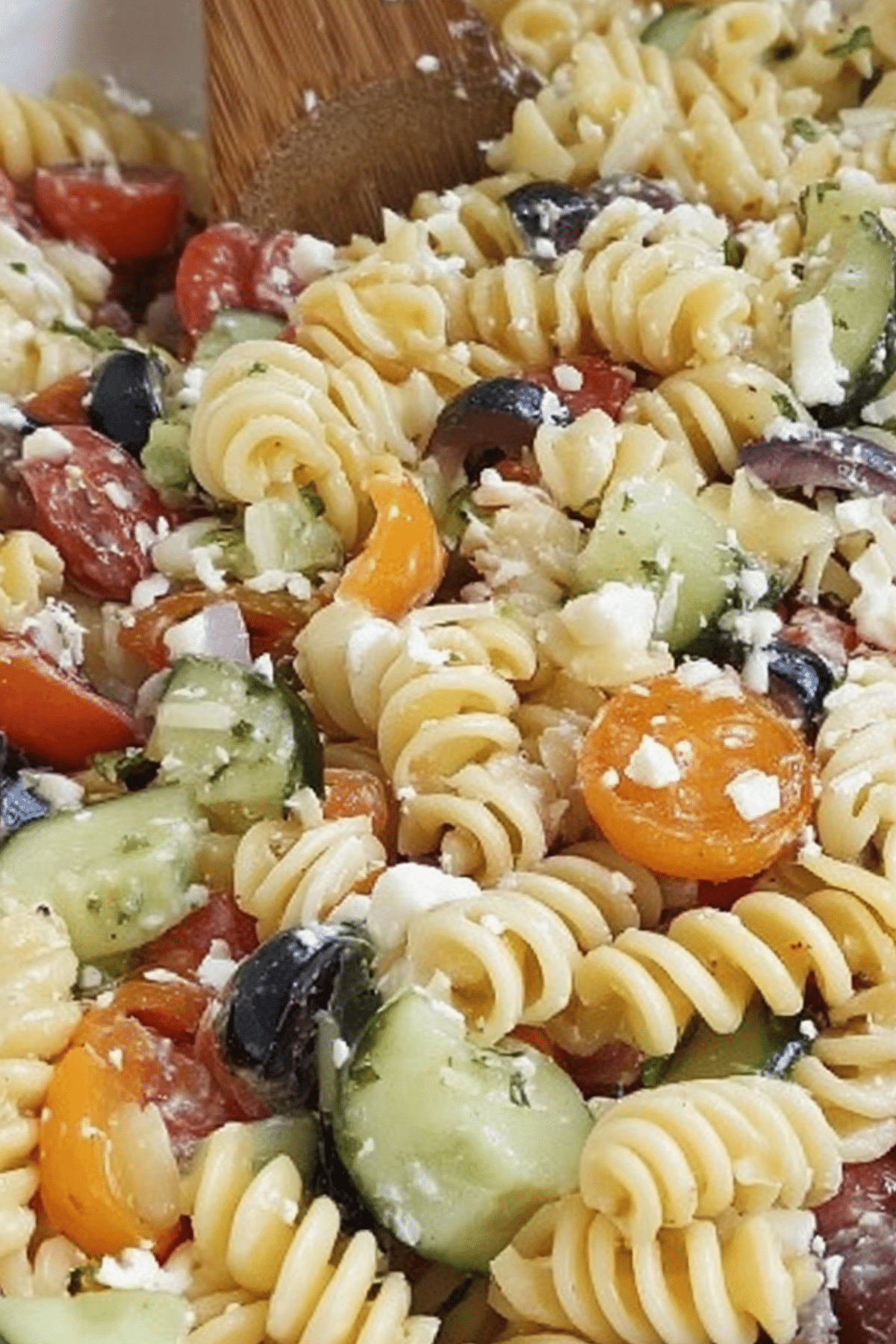 "Italian Pasta Salad with rotini, feta, tomatoes, olives, and dressing"