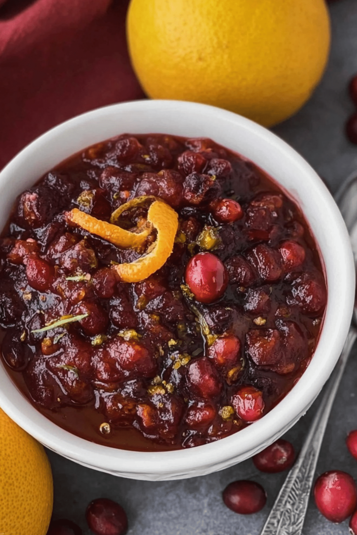 Homemade Fresh Cranberry Orange Sauce in a bowl with cranberries and orange zest