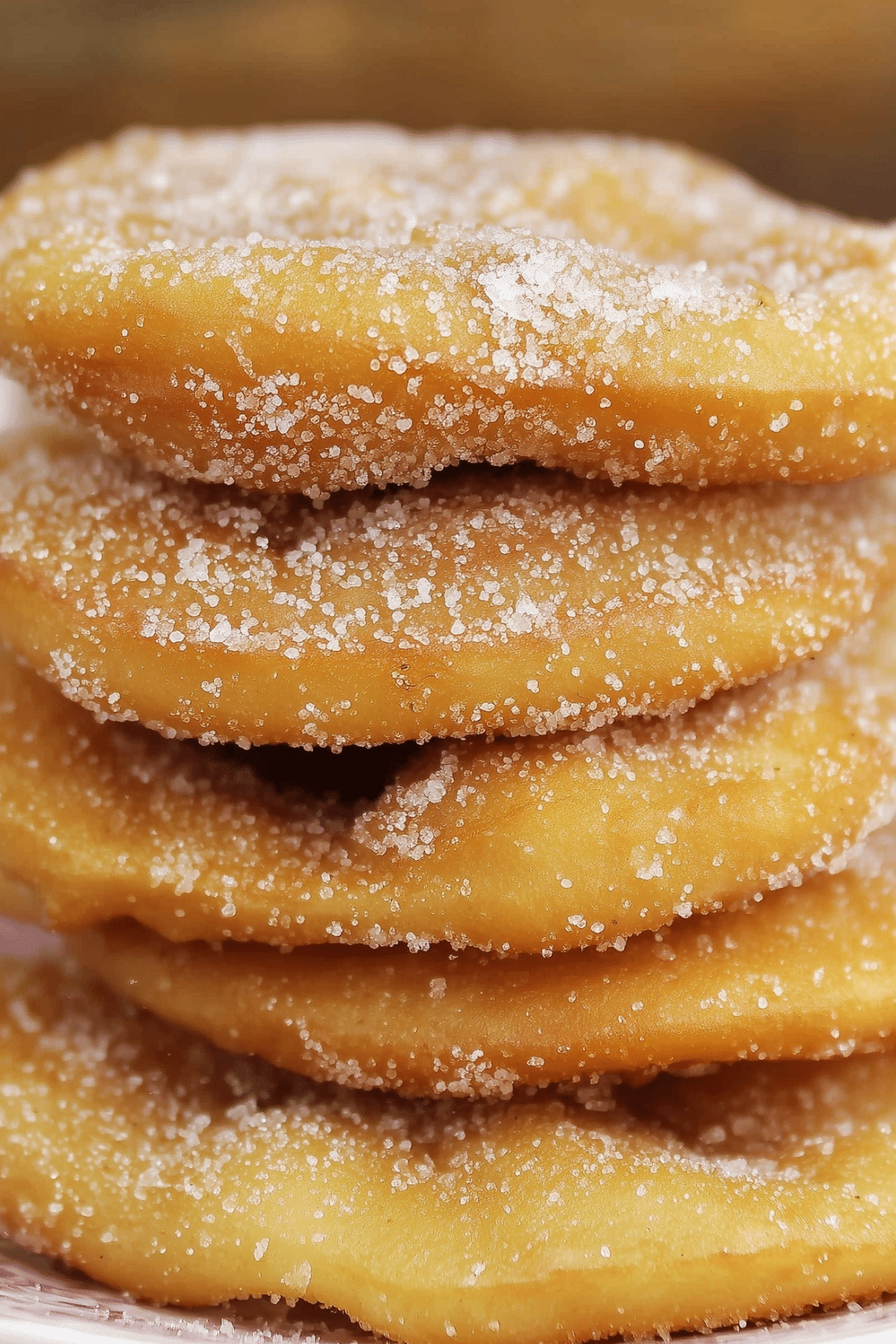 Bunuelos coated in cinnamon sugar on a plate
