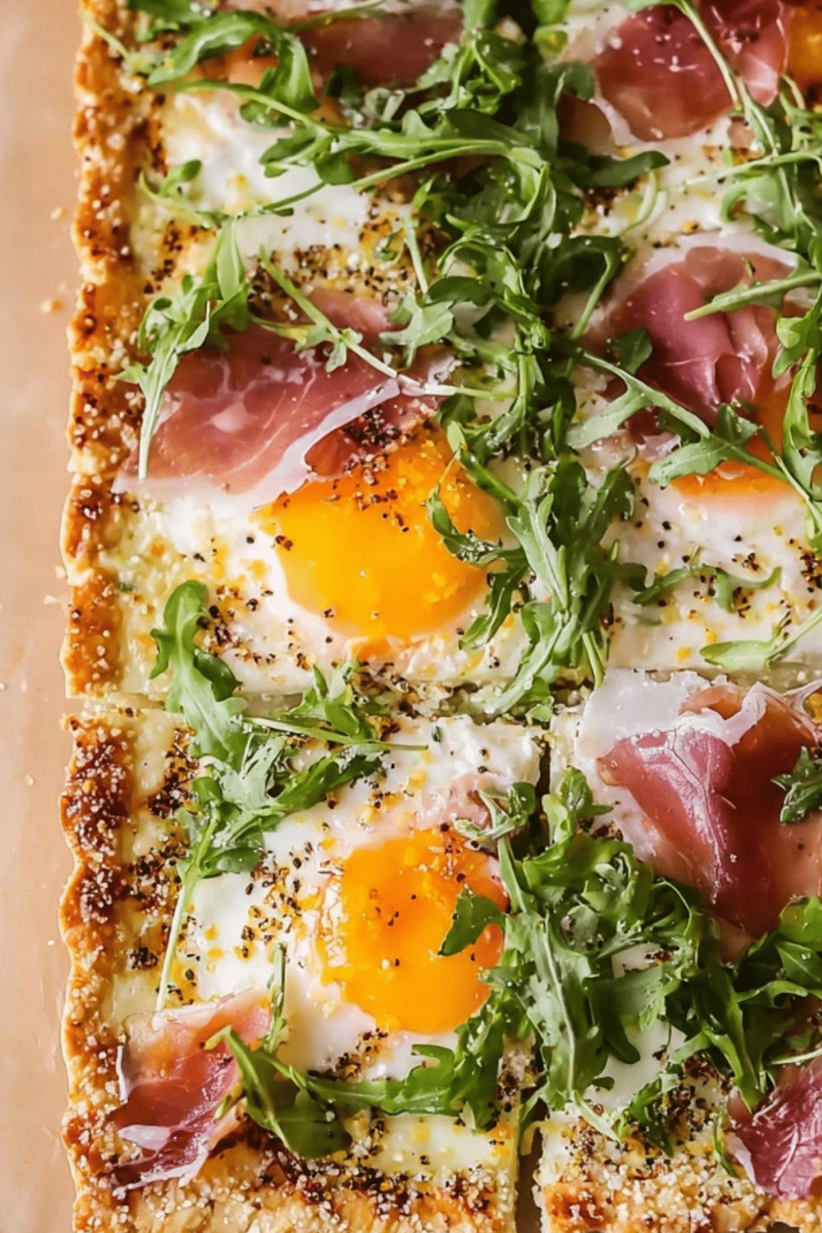 Baked Prosciutto and Egg Breakfast Tart on puff pastry with arugula