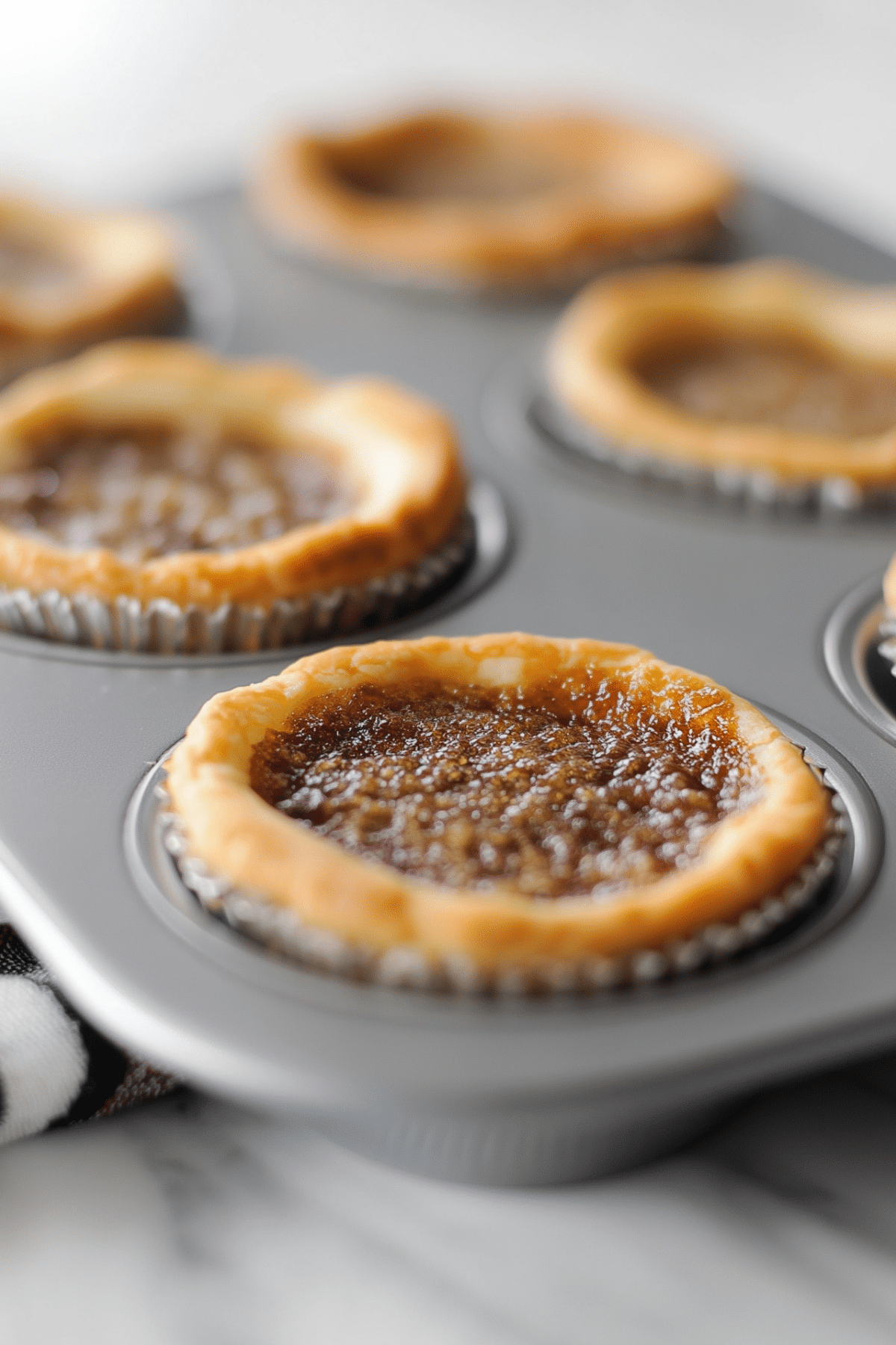 Classic Butter Tarts on a plate with flaky crust and gooey caramel filling