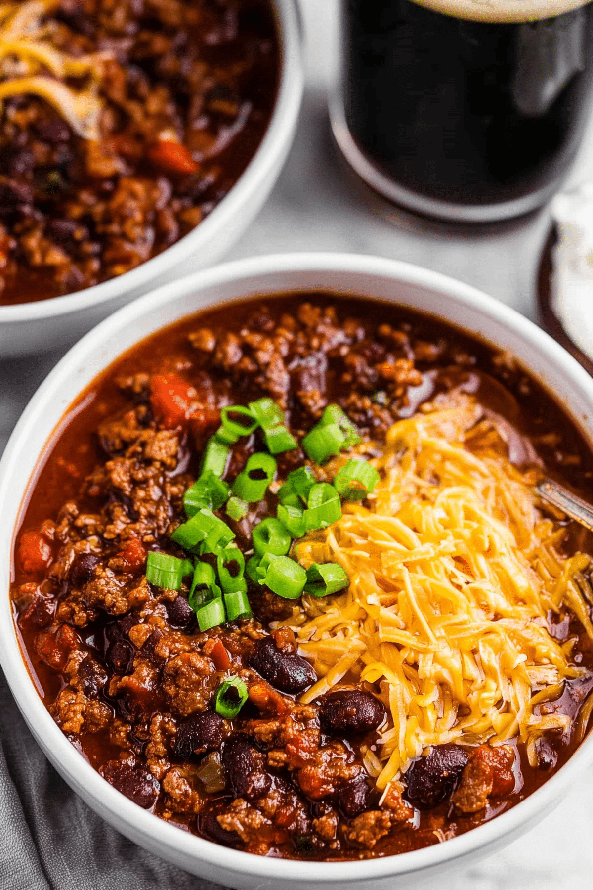 Guinness Spiked Irish Chili served in a bowl with sour cream and cheddar