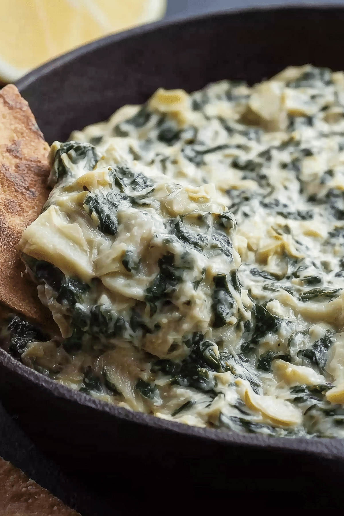 Creamy baked Spinach Artichoke Dip served hot with pita chips