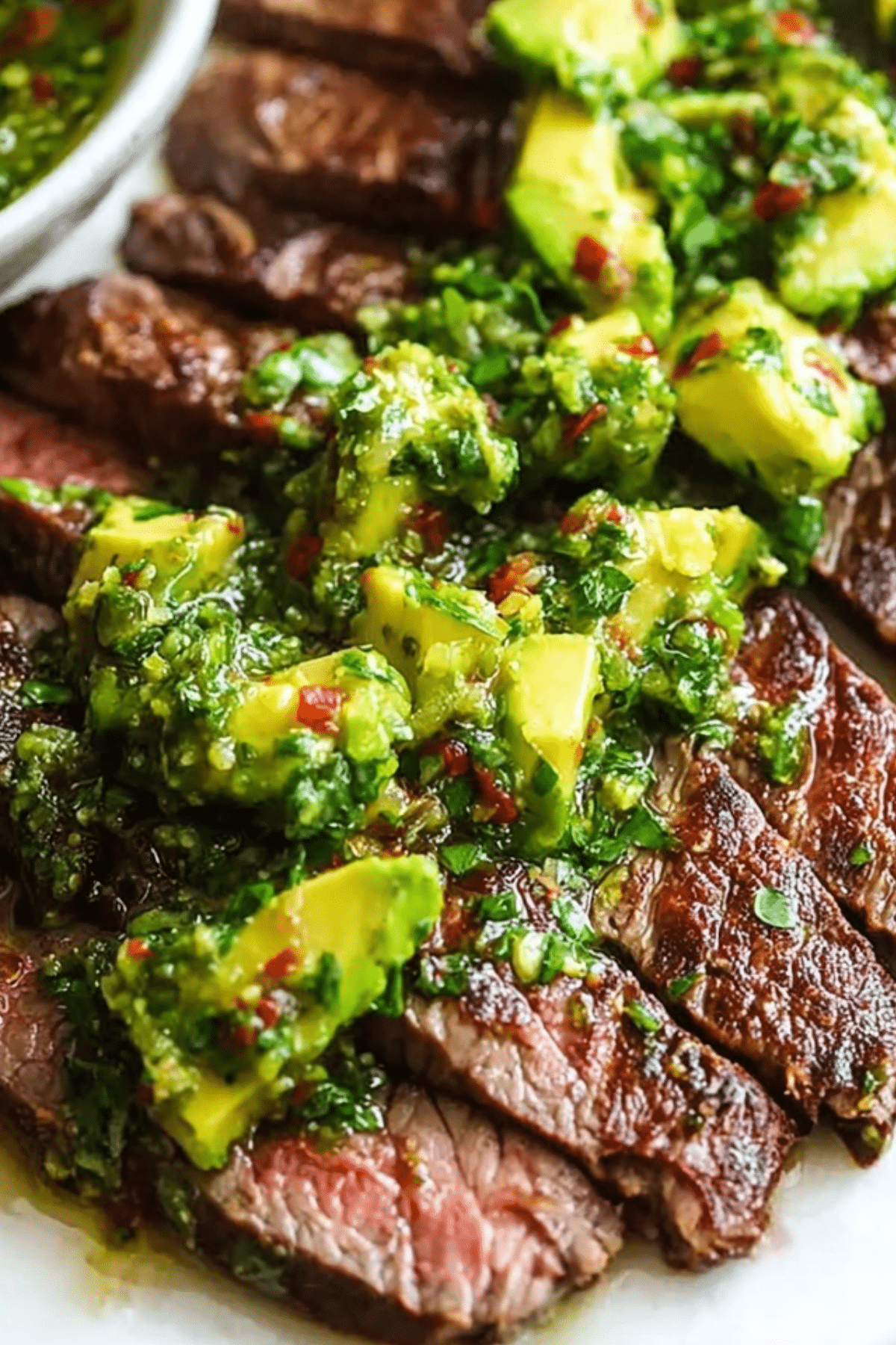 Skirt Steak with Avocado Chimichurri served on a plate with vibrant chimichurri sauce