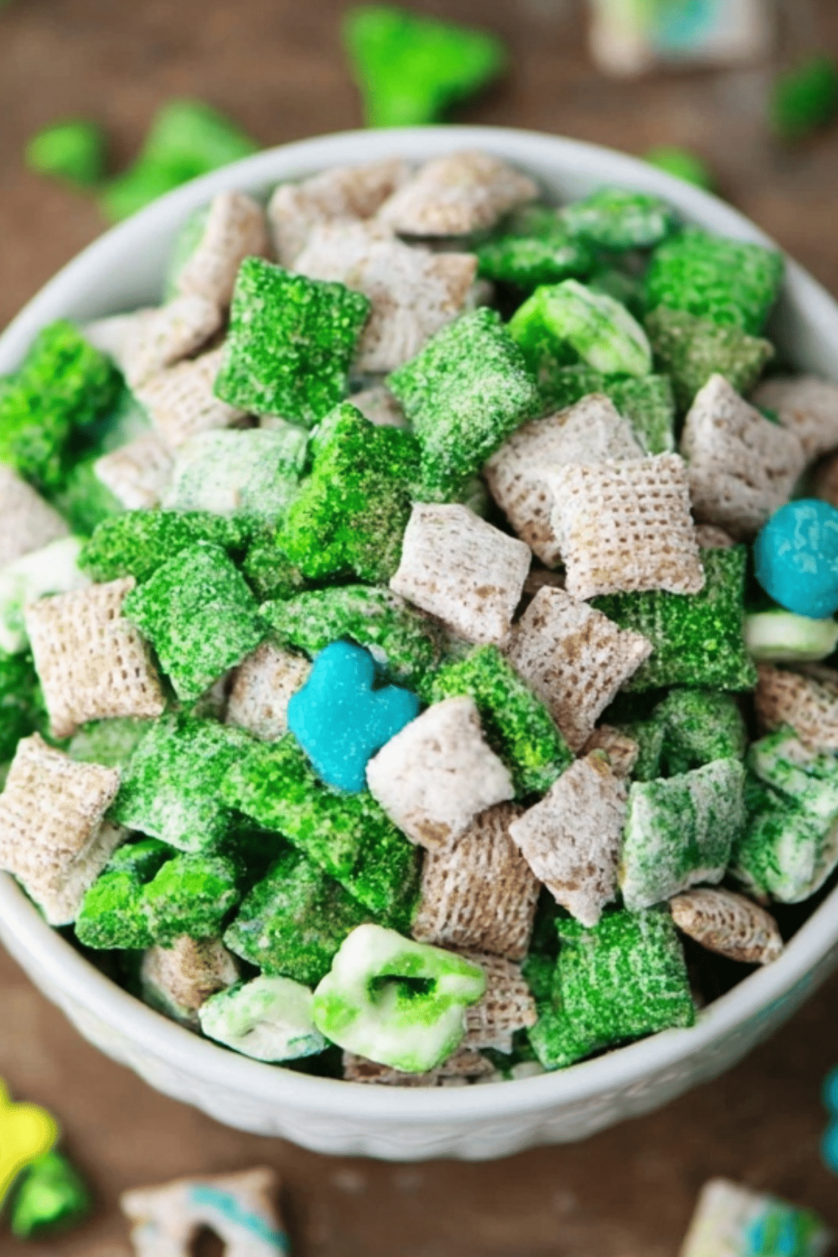 St Patrick’s Day Muddy Buddies coated in powdered sugar with green candies