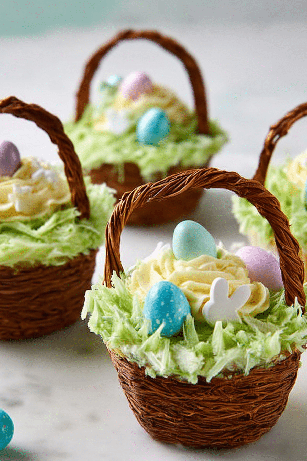 Easter Basket Cupcakes decorated with green coconut grass and candy eggs